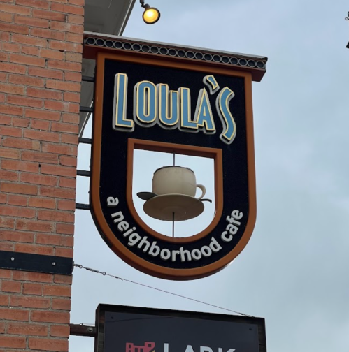 Sign for Loula's, a neighborhood café, featuring a coffee cup graphic against a brick background.