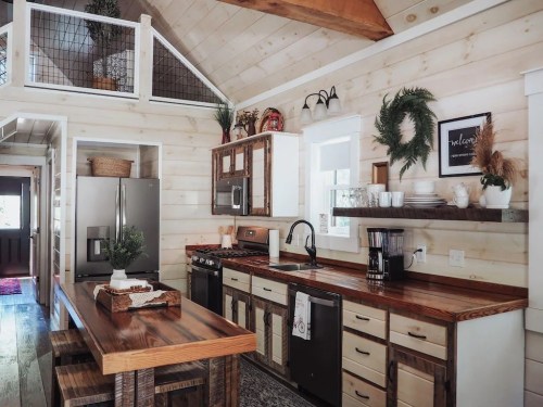Cozy kitchen with wooden accents, modern appliances, and a rustic dining table in a bright, airy space.