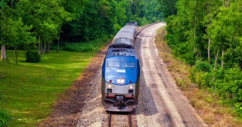 an amtrak train rolling on the tracks in rural michigan