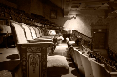 Empty theater seats in a vintage setting, softly lit, creating a nostalgic atmosphere.