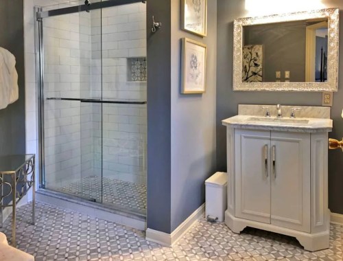 Modern bathroom featuring a glass shower, double sink vanity, and decorative wall art. Elegant tile flooring completes the look.