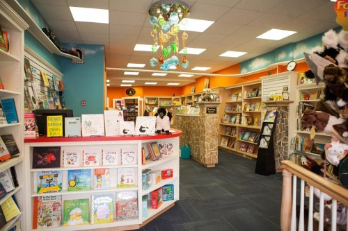A colorful children's bookstore with shelves of books, a playful decor, and a cozy reading area.