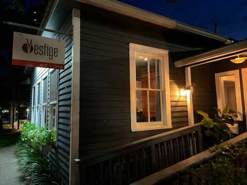 A cozy restaurant exterior at night, featuring a sign that reads "Vestige" and warm lighting from the windows.