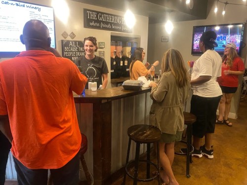 A lively bar scene with people chatting, ordering drinks, and enjoying a social atmosphere.
