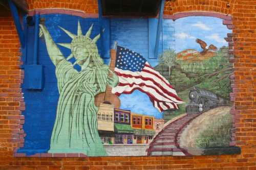 A colorful mural featuring the Statue of Liberty, an American flag, a train, and a scenic landscape.