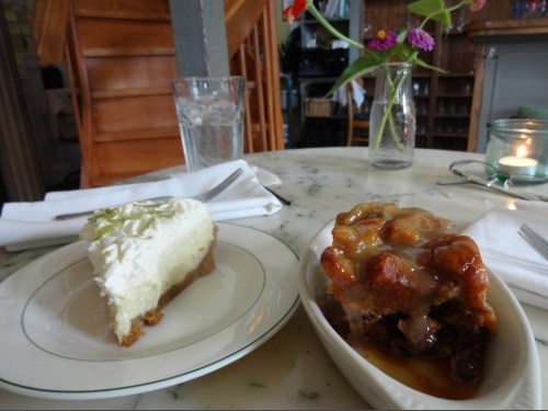 A slice of lime pie and a serving of bread pudding with caramel sauce on a marble table.