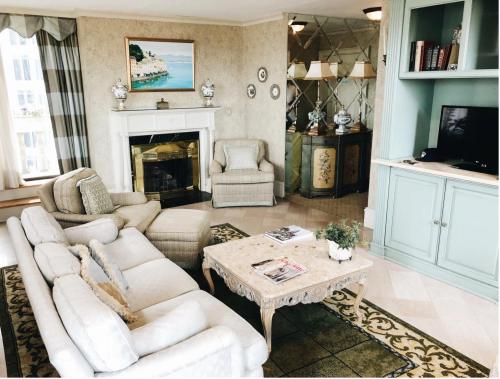 Cozy living room with a fireplace, elegant furniture, and decorative accents in soft colors.