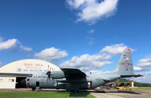 A U.S. Air Force C-130 aircraft parked at Drake Field Air Museum under a blue sky with clouds.