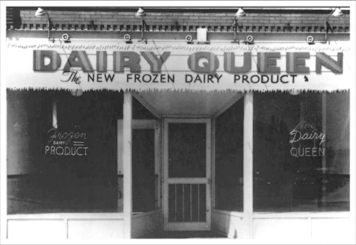 Black and white image of a Dairy Queen storefront with a sign reading "The New Frozen Dairy Product."