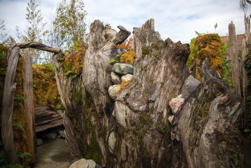 A serene garden pathway surrounded by weathered wooden structures and lush greenery.