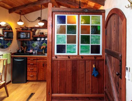 A cozy kitchen with wooden accents, colorful stained glass, and a rustic door, creating a warm, inviting atmosphere.