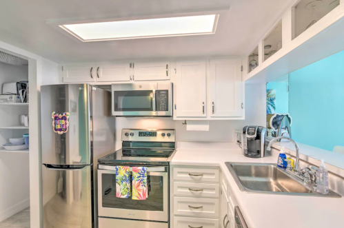 Modern kitchen with white cabinets, stainless steel appliances, and a bright, airy atmosphere.