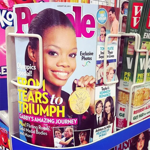 Cover of People magazine featuring a smiling athlete holding a gold medal, with headlines about her journey and other celebrity news.