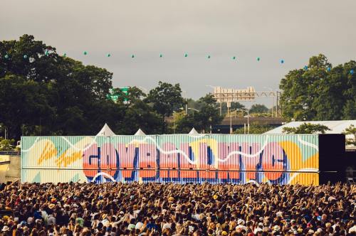 A large crowd at a music festival in front of a colorful stage backdrop with the word "GOVERNOR'S" displayed.