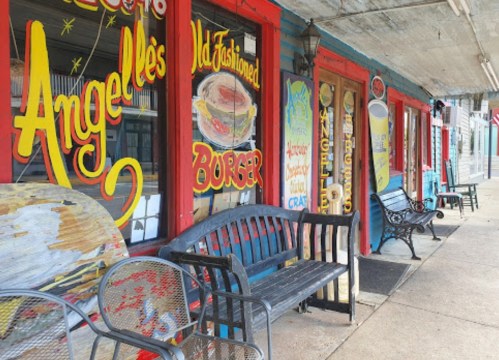 Colorful storefronts with vintage signs for "Angelle's" and "Old-Fashioned Burger," featuring benches along the sidewalk.