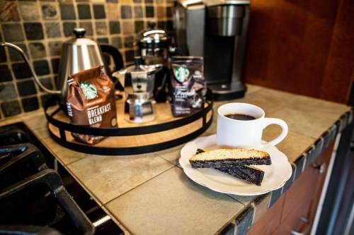 A cozy kitchen scene featuring coffee, biscotti, and a coffee maker on a countertop.