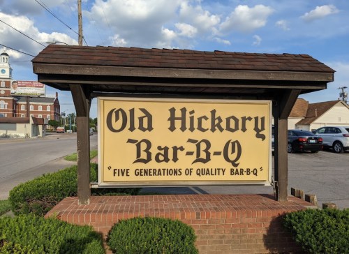 Sign for Old Hickory Bar-B-Q featuring the text "Five Generations of Quality Bar-B-Q" against a blue sky backdrop.