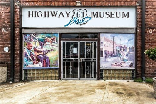 Entrance of the Highway 61 Blues Museum, featuring colorful murals and a decorative metal gate.