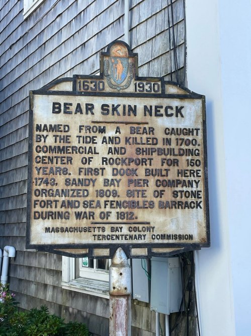 Historical sign about Bear Skin Neck, detailing its origins and significance in Rockport, Massachusetts.