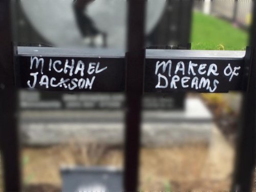 Sign on a fence reads "Michael Jackson" and "Maker of Dreams" in white lettering.