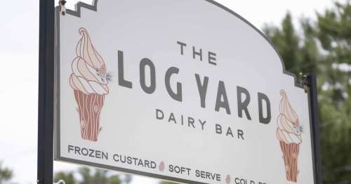 Sign for "The Log Yard Dairy Bar" featuring ice cream cones and text about frozen custard and soft serve.