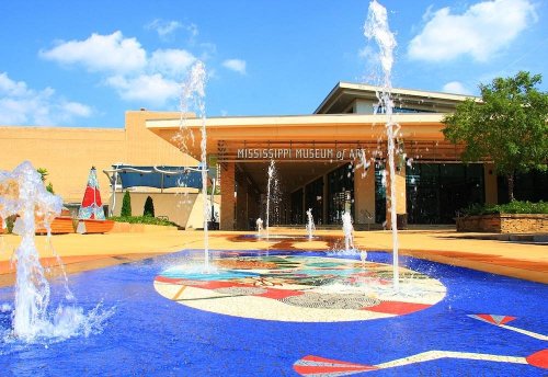 Entrance of the Mississippi Museum of Art, featuring a colorful fountain and blue mosaic in the foreground.