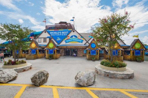 Entrance to a colorful waterpark with a sign reading "World's Best Waterpark," surrounded by greenery and rocks.