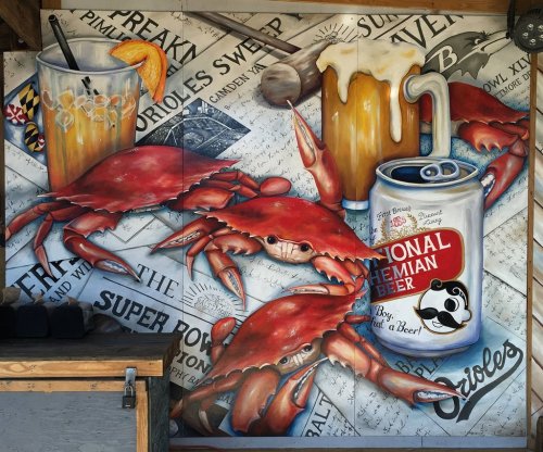 Colorful mural featuring crabs, beer, and cocktails, celebrating local culture and the Baltimore Orioles.