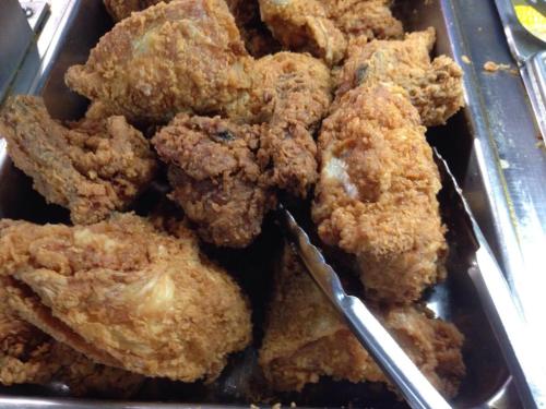 A close-up of crispy, golden-brown fried chicken pieces in a serving tray.