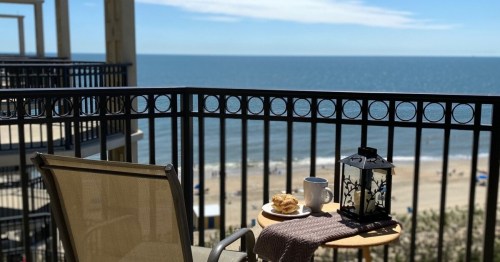a chair and table on a patio overlooking the ocean in delaware