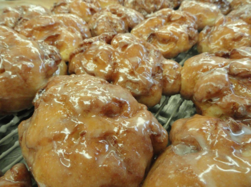 Close-up of freshly baked, glazed cinnamon rolls on a cooling rack, glistening with sweet icing.