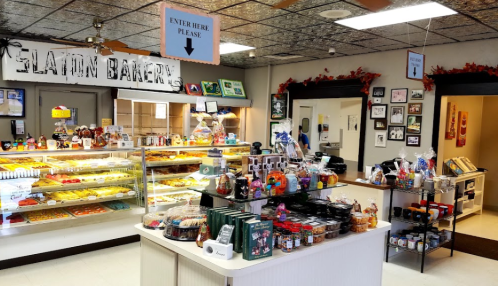 A cozy bakery interior with display cases of pastries, a colorful counter, and decorative autumn-themed accents.