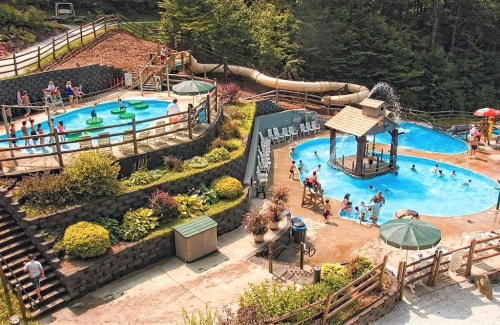 Aerial view of a water park with pools, slides, and people enjoying the sun and water activities.