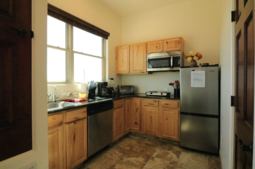 A cozy kitchen featuring wooden cabinets, stainless steel appliances, and a window with natural light.