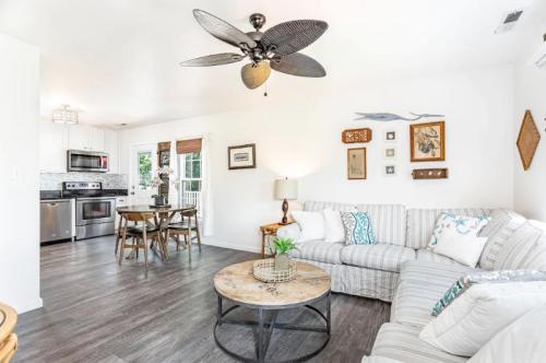 Cozy living room with a striped sofa, round coffee table, and a dining area, featuring modern decor and natural light.