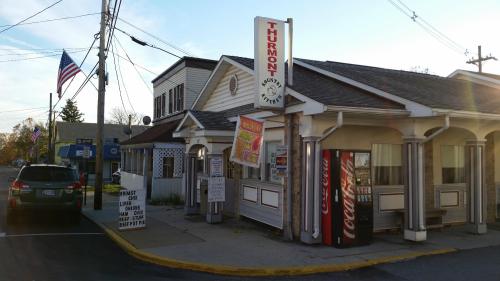 A small diner with a sign reading "Turmon," featuring a Coca-Cola vending machine and an American flag nearby.