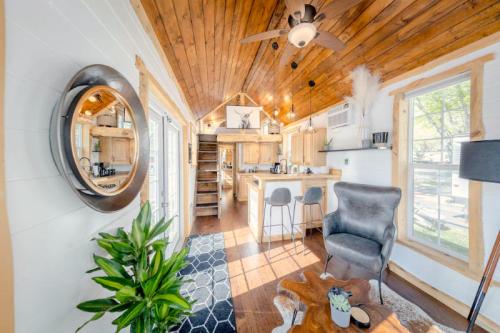 Cozy interior of a tiny home featuring wooden beams, a kitchen, living area, and stylish decor with plants.