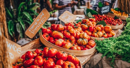 Baskets of various tomatoes at a farmers market.