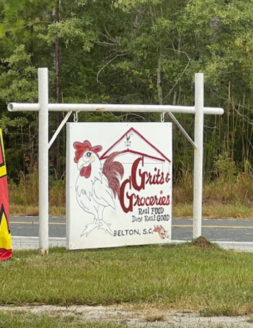 Sign for "Grits & Groceries" featuring a rooster, located in Belton, S.C., with a rustic design and vibrant colors.