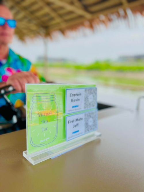 A virtual tip jar display with names "Captain Kevin" and "First Mate Jeff" on a table by the water.
