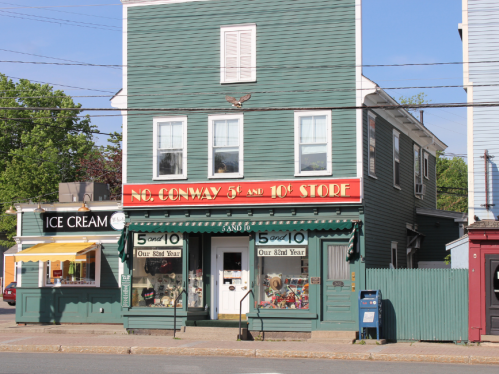 A green building with a red sign reading "No. Conway 5¢ and 10¢ Store" next to an ice cream shop.