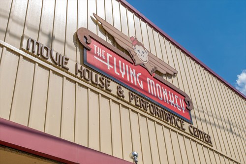 Sign for The Flying Monkey Movie House & Performance Center, featuring a monkey and vintage airplane design.