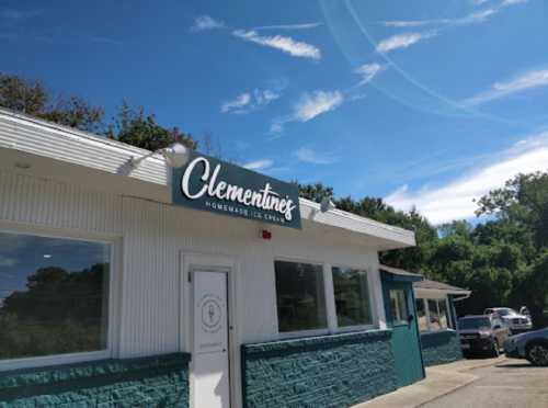 A bright blue sky above a white building with a sign reading "Clementine's Homemade Ice Cream."