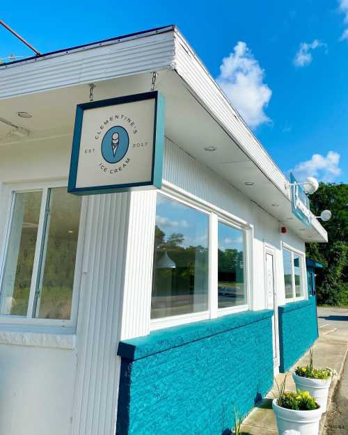 Exterior of Clementine's Ice Cream shop, featuring a sign and bright blue accents under a clear sky.