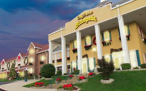 A festive hotel exterior decorated with holiday lights and wreaths, set against a twilight sky.