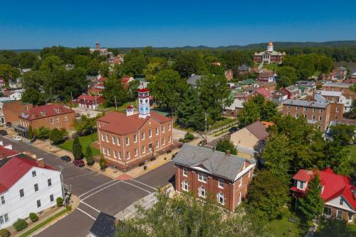 Aerial view of a small town with historic buildings, green trees, and a clear blue sky.