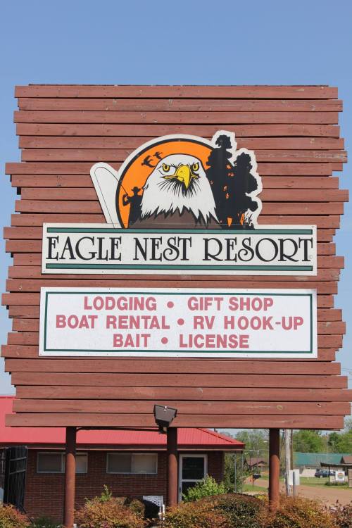 Sign for Eagle Nest Resort featuring services like lodging, boat rental, and a gift shop, with an eagle logo.