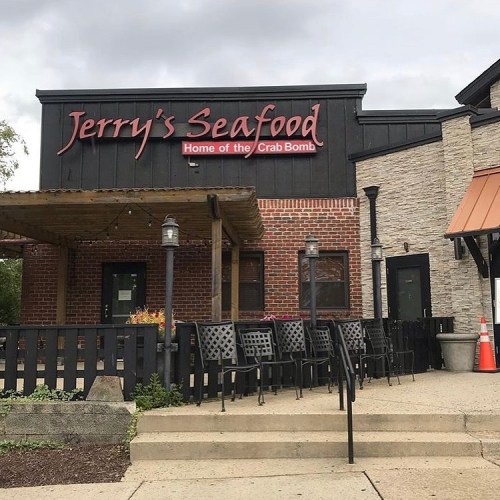 Exterior of Jerry's Seafood restaurant, featuring a sign that reads "Home of the Crab Bomb" and outdoor seating.