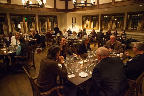 A cozy restaurant scene with diners at tables, enjoying meals and conversation in a warmly lit atmosphere.