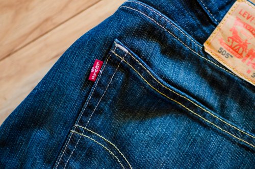 Close-up of a pair of blue jeans featuring a Levi's tag on the back pocket and a leather label on the waistband.